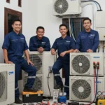 Tim teknisi AC berfoto bersama setelah bekerja di Jakarta